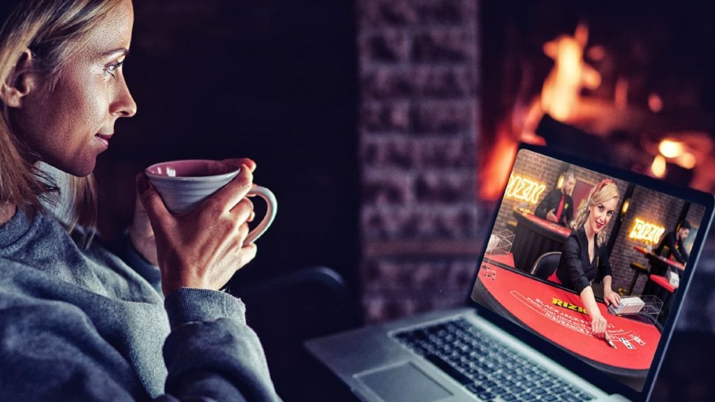 Woman playing on the laptop while drinking tea in Rizk casino